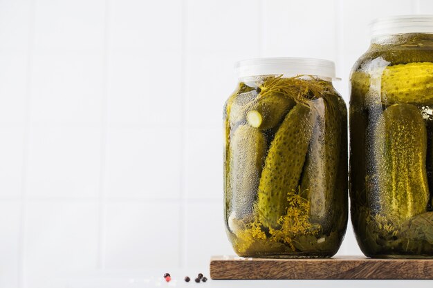 Pickled cucumbers in jars on a white background canning vegetables copy space