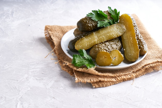 Pickled cucumbers with herbs and onions in a plate on the table Probiotics food