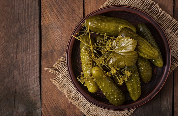 Pickled cucumbers on wooden background