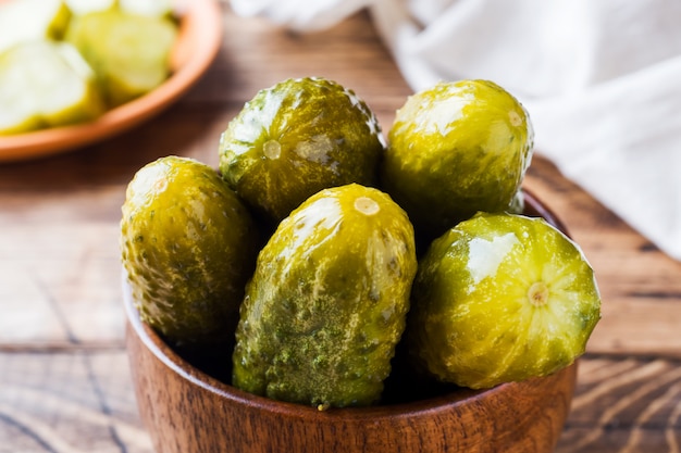 Pickled cucumbers in a wooden bowl dark rustic background