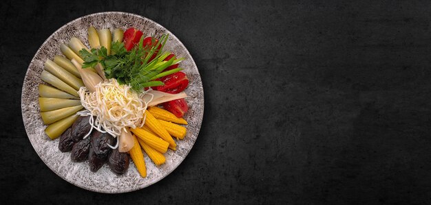 Pickled and fresh vegetables with cheese on a plate Banner