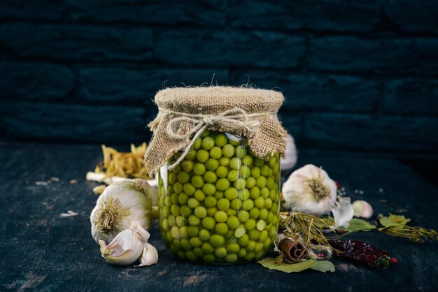 Pickled green peas in a jar Stocks of food Top view On a wooden background Copy space