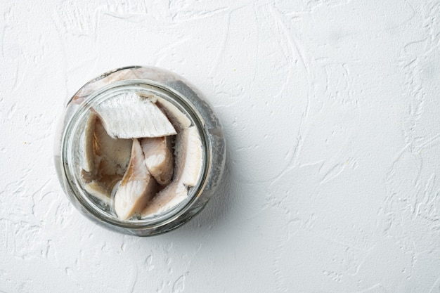 Pickled herring set, in glass jar, on white