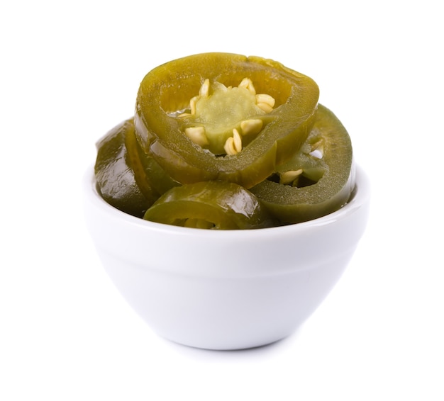Pickled jalapeno pepper in ceramic bowl, isolated on white background. Slices of preserved hot serrano.