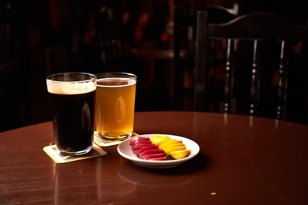 Pickled Marinated eggs pink and yellow on a white plate and glass of beer in pub