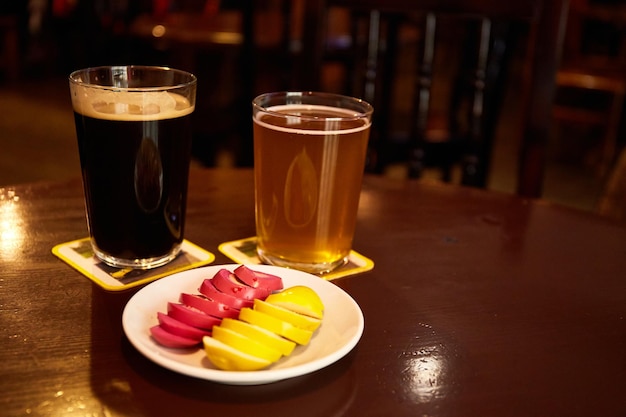 Pickled Marinated eggs pink and yellow on a white plate and glass of beer in pub