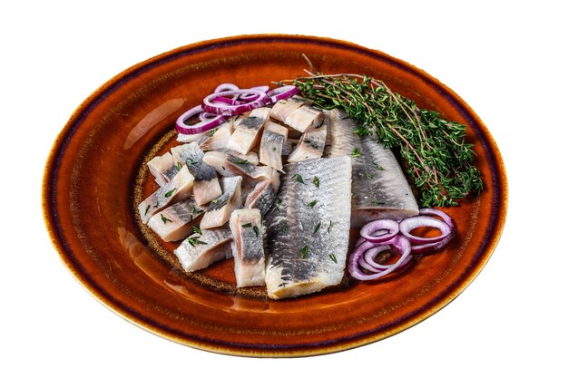 Pickled marinated herring fish sliced fillet on a plate with thyme and onion Isolated on white background