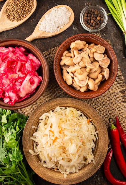 Pickled mushrooms sauerkraut cabbage salad with beets on the tableFermented food Homemade food Pickled vegetables Top view flat lay Copy space Culinary background