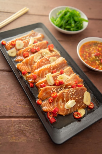 Pickled salmon with shoyu or soy sauce and spicy dipping sauce\
thai style food.