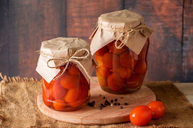 Pickled tomatoes in glass jar on wooden background Fermented trending food Home rustic style