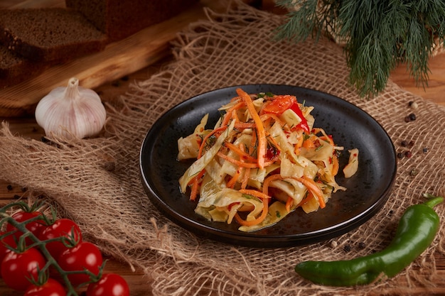 Pickled white cabbage in the plate, wooden