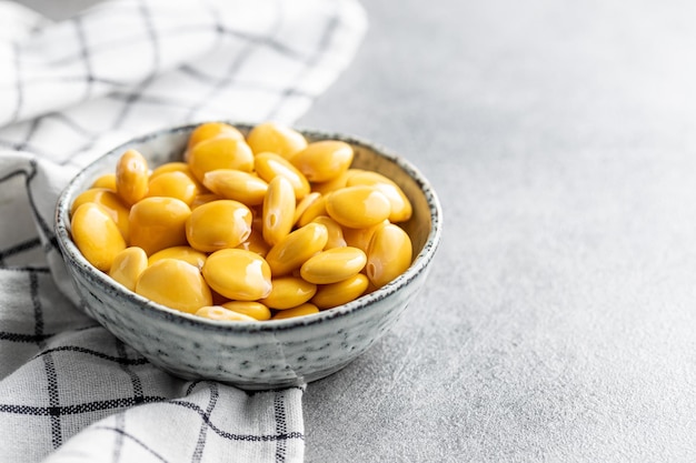 Foto fagioli lupini gialli marinati in una ciotola sul tavolo della cucina