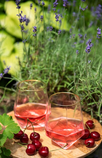 Picknick buiten in lavendelvelden. rose wijn in een glas, kersen op een houten plank