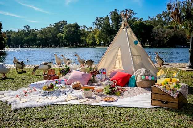 Picknick in deken en tent in het park met het meer.