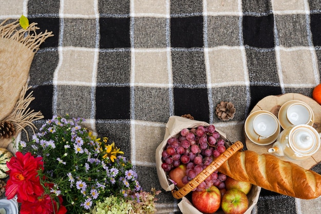 Foto picknick in het herfstbos met bloemen pompoenen appels herfstvakantie