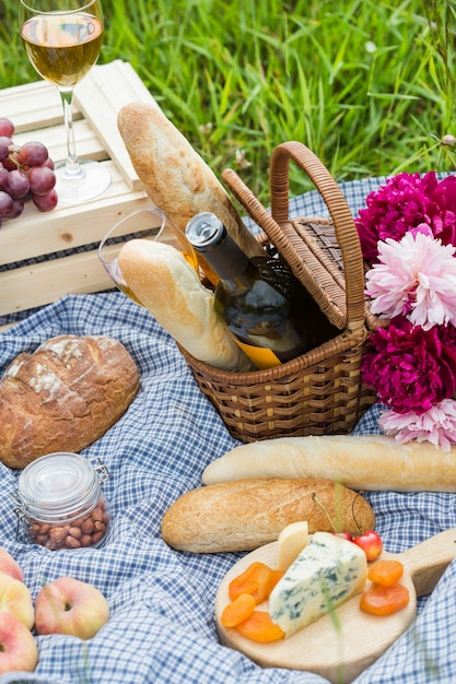 Picknick in het park op het gras: wijn, kaas en brood