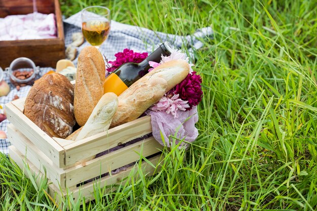 Picknick in het park op het gras: wijn, kaas en brood