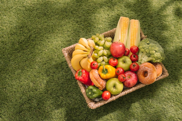 Picknick op het gras. Rood geruit tafelkleed, mand, gezonde voeding en fruit, jus d'orange. Bovenaanzicht. Zomertijd rust. Plat leggen.