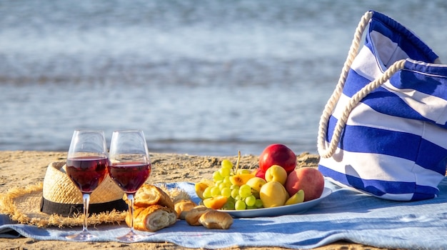 Picknickkleed, wijn, fruit, prachtig zeestrand Natuur Selectieve aandacht