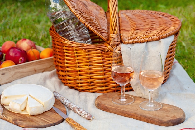 Picknickmand met verschillende snacks op het groene gras in de tuin