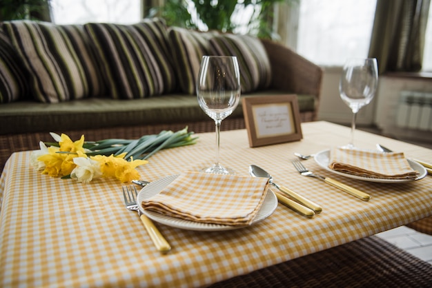 Foto picknickset. bestek, tafelkleed, mand, lepels, vorken, messen, glazen, servetten. romantische date. familie weekend. gele cel. perfecte familie. narcissuses. een frame voor tekst of foto.