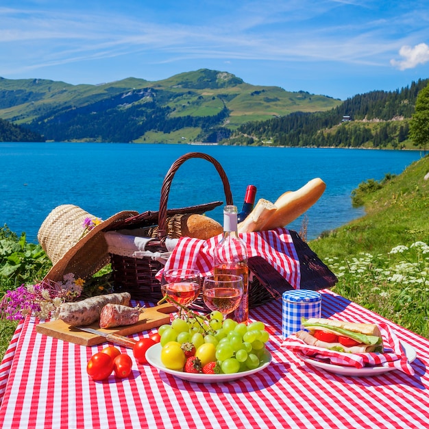 Picnic in alpine mountains with lake on background, panoramic view