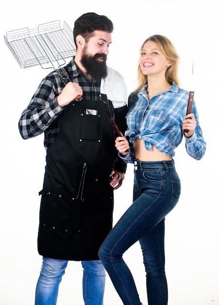 Picnic and barbecue Man bearded hipster and girl ready for barbecue party Culinary concept Family weekend Couple in love hold cooking utensils for barbecue Tools for roasting meat outdoors