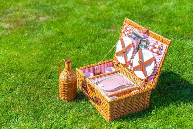 Picnic basket on green lawn in the park