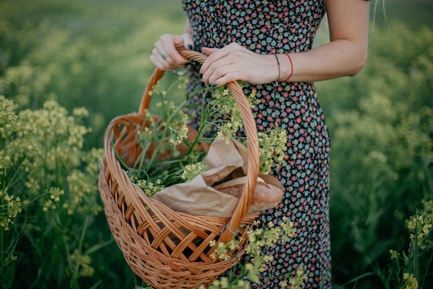 Foto cesto da picnic con pane sullo sfondo di un campo di colza