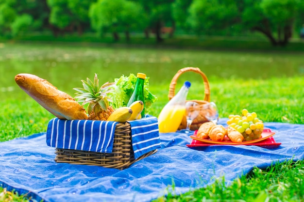 Корзина для пикника с фруктами, хлебом и бутылкой белого вина