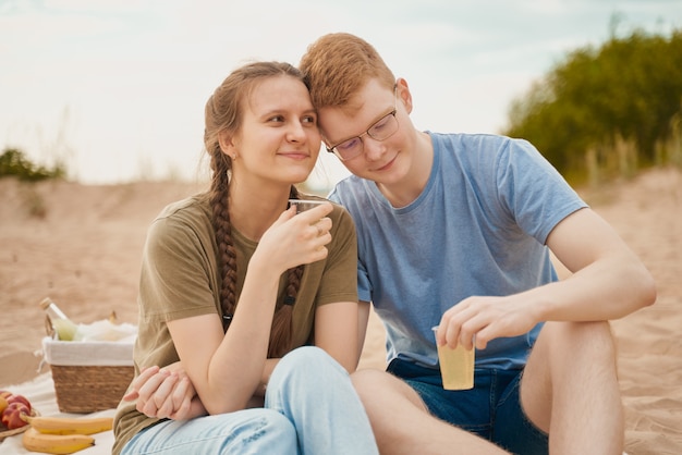 Picnic on beach with food and drinks.