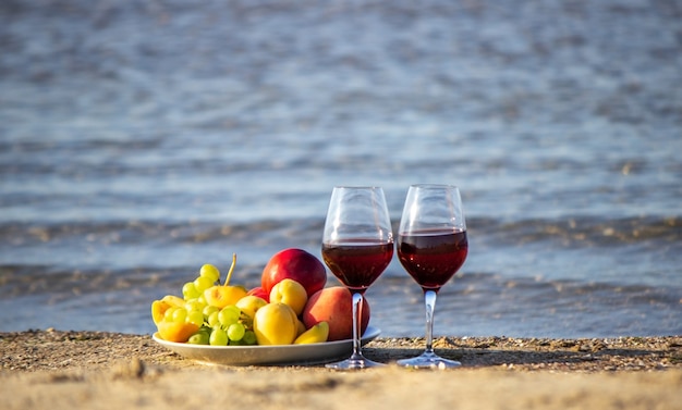 ピクニック毛布、ワイン、フルーツ、美しい海のビーチ自然選択的な焦点