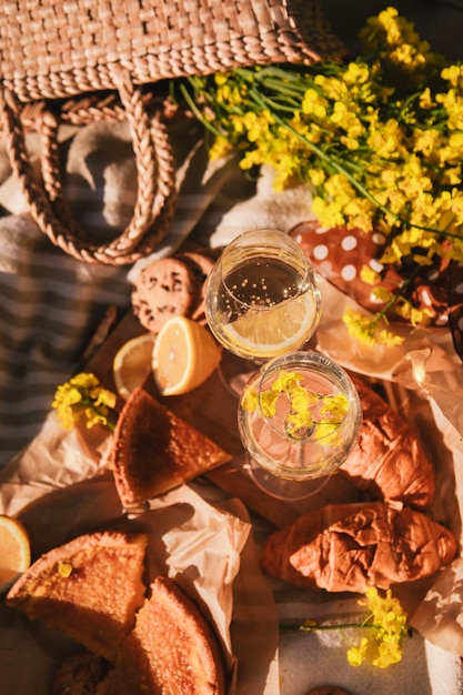 Picnic concept glasses of wine bun outdoors on blanket summertime