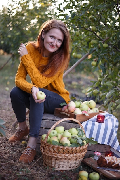 Picnic in the garden. happy girl and basket  with juicy apples in the garden