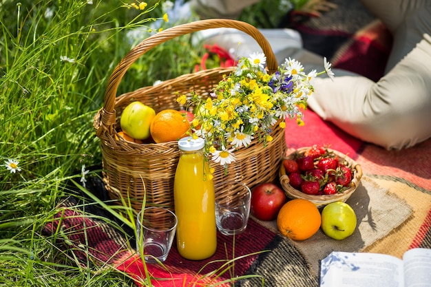 Picnic on the grass juice a bouquet of wild flowers fruitPicnic at the park on the grasshealthy food and accessoriesPicnic Grass Summer Time Rest