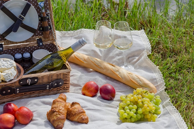 Picnic on the lake: tablecloth, picnic basket with tableware