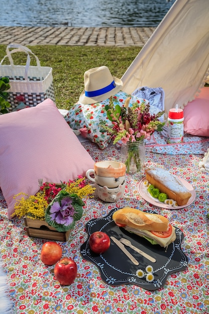 Picnic lunch in the park. Sandwiches, apples and flowers.