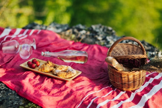 Picnic nella natura con croissant e una bottiglia di vino bianco