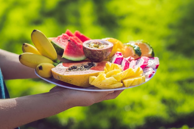 Picnic at the park on the grass: A plate of tropical fruits against the background of grass.