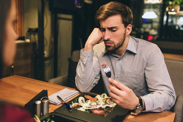 Pictue van man die samen met zijn vriendin zit en wat eten eet dat ze hebben besteld