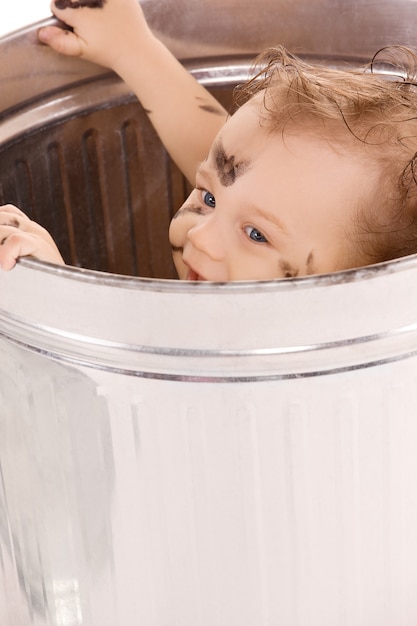 Photo picture of adorable baby in trash can