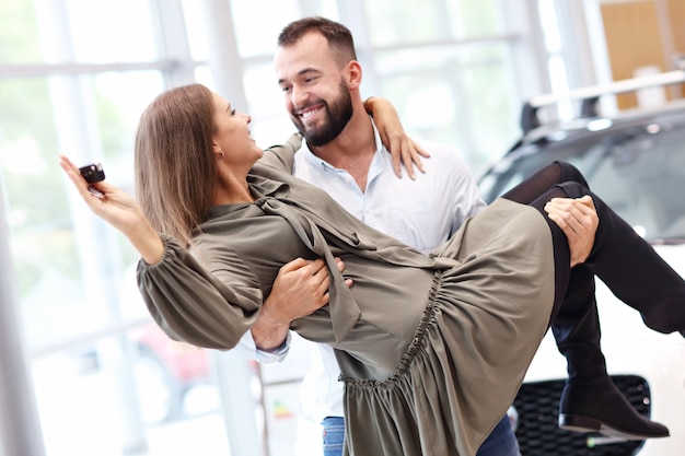 Picture of adult couple choosing new car in showroom