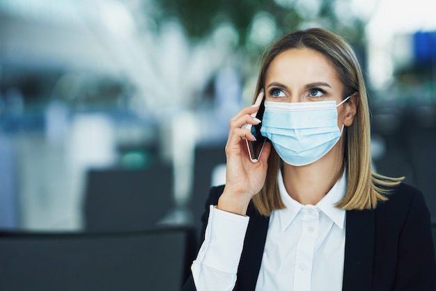 Immagine di una passeggera adulta che utilizza lo smartphone in aeroporto