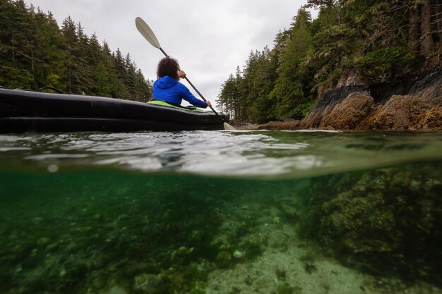 Over and Under picture of an Adventurous woman kayaking in the Pacific Ocean