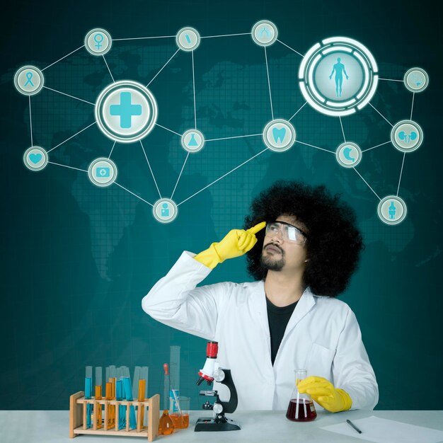 Picture of african male scientist thinking an idea while doing chemical research. shot with virtual screen background
