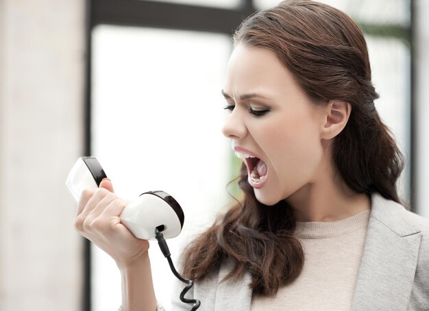 Foto immagine di imprenditrice arrabbiata che grida al telefono