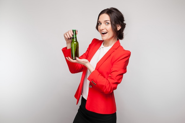 Picture of attractive woman in red dress with green beer in hands