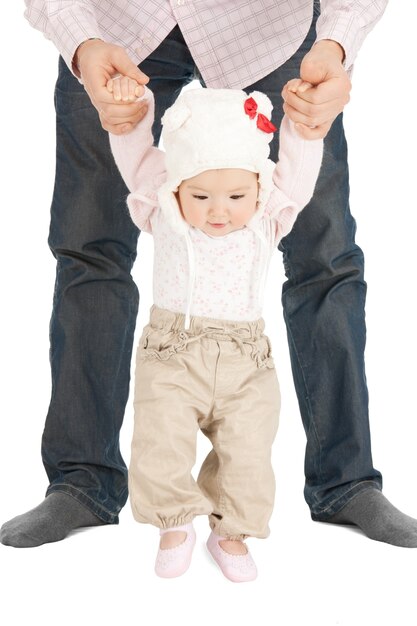 picture of baby making first steps with father help