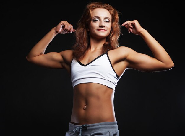 Picture of beautiful sporty muscular woman isolated on black background