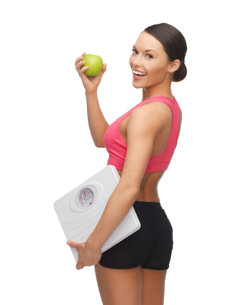 picture of beautiful sporty woman with scale and green apple